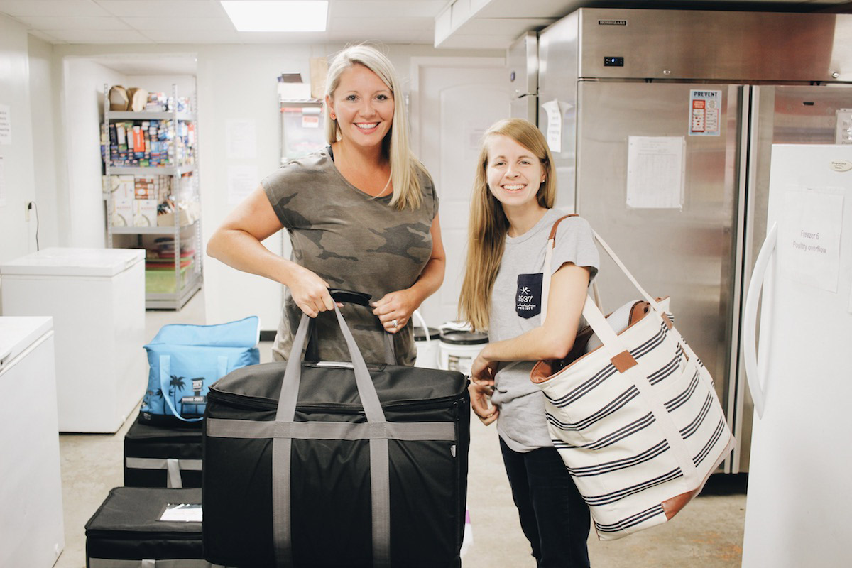 Two Scarlet Hope volunteers carrying meal bags for outreach